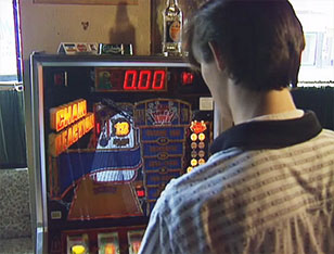 Guy playing fruit machine in a pub